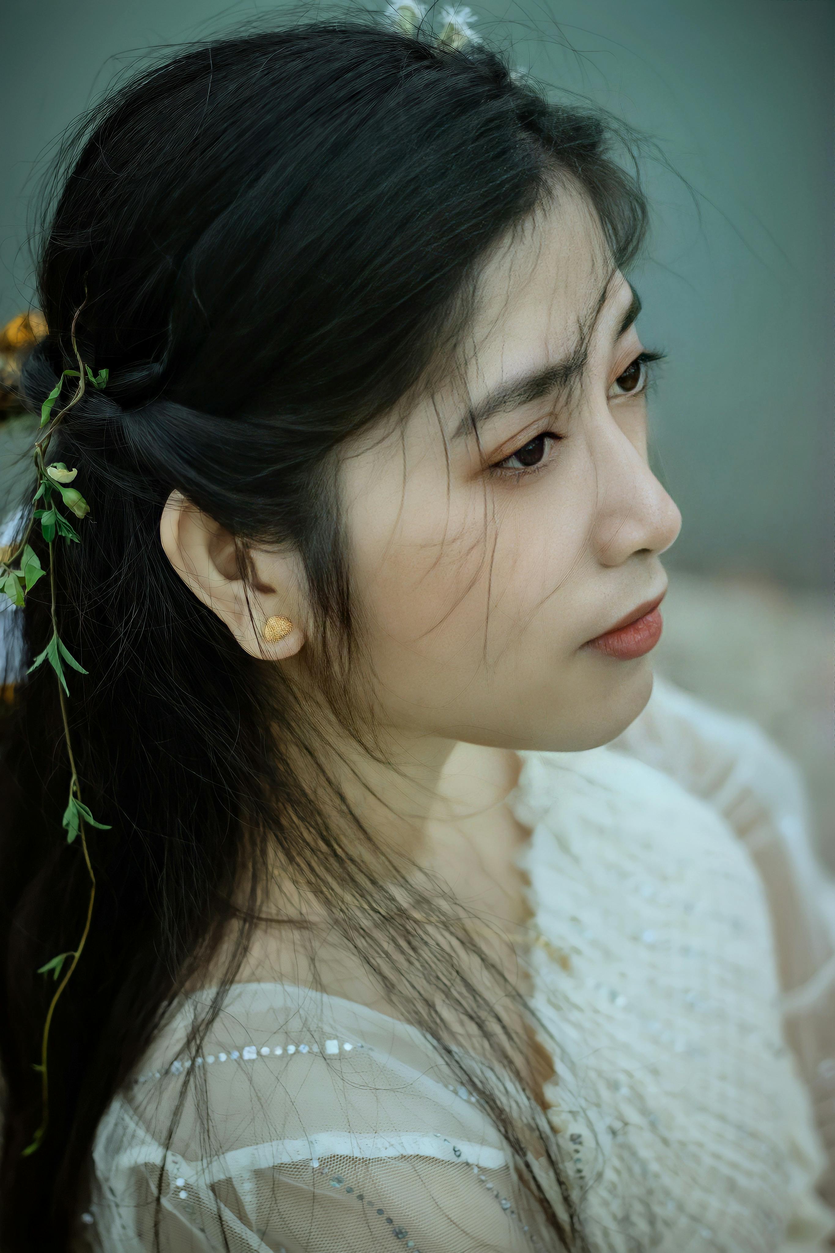 Elegant profile of a woman with floral decorations in her hair, exuding tranquility.