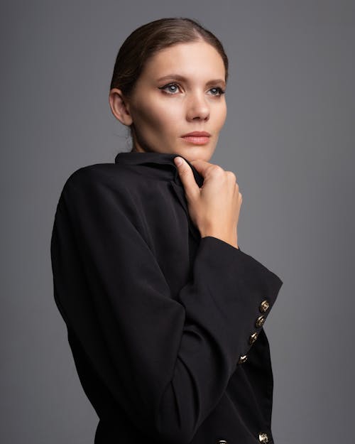 Woman in Black Coat With Hand on Her Chin