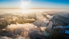 鸟瞰图中，城市雾与阳光交相辉映，展现了自然与建筑的完美融合