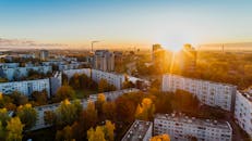 秋日晨曦中，俯瞰城市景观，现代建筑与秋叶相映成趣