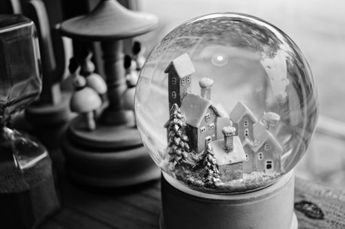 Free Charming black and white snow globe displaying a quaint winter village scene. Stock Photo