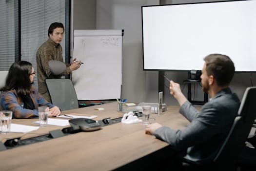 Colleagues engaged in a presentation meeting inside a modern office setting.