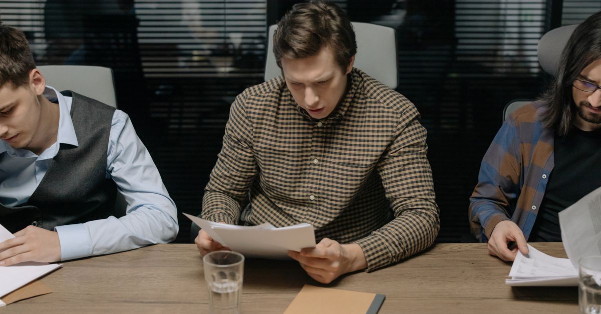 three interviewers reviewing candidate documents at table