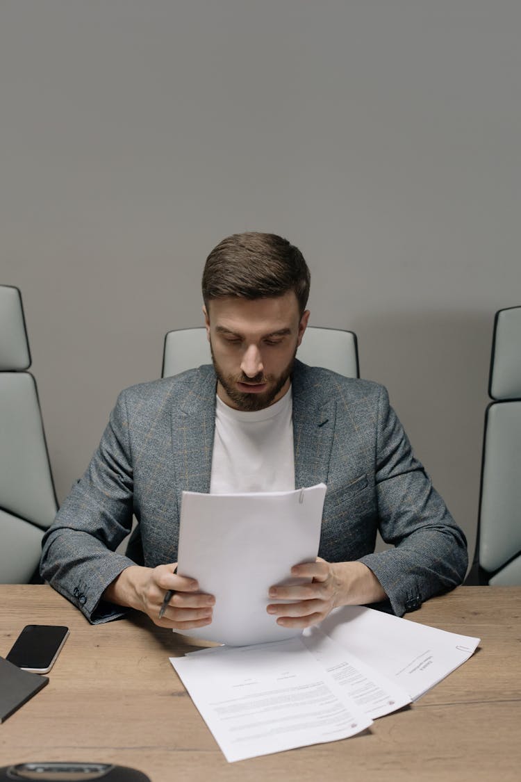 Man In Gray Suit Jacket Holding Papers