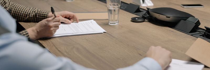 Professional setting of a business meeting with individuals signing documents on a conference table.