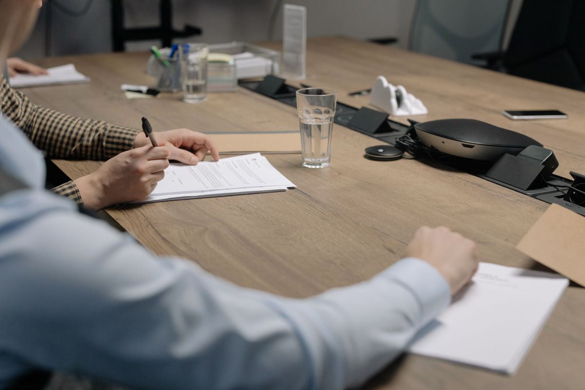 A brand owner signing a manufacturing supply agreement at a meeting table
