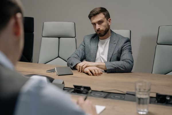Two people in a formal meeting discussing documents