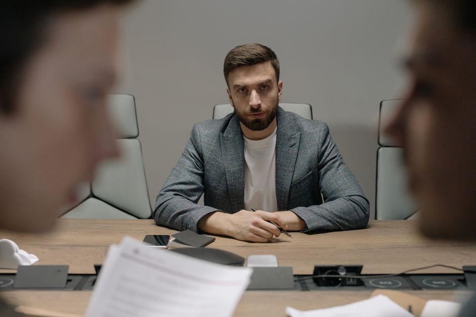 Photo by cottonbro studio on Pexels Serious businessmen engaged in a formal meeting around a conference table.