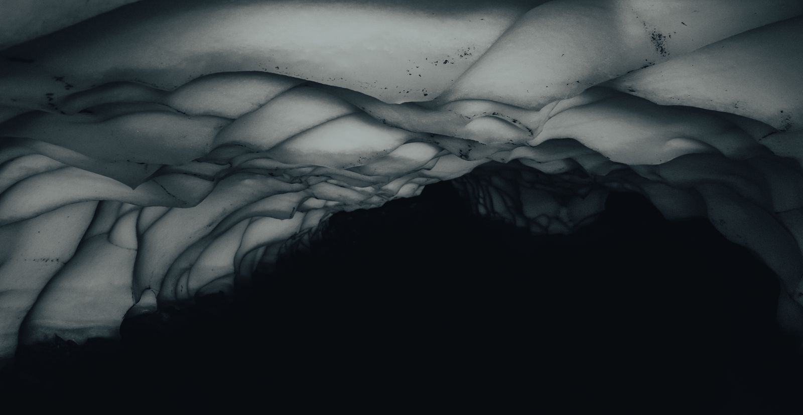 Dark, layered glacier ice-cave wall — photo by Gaspar Zaldo on Pexels