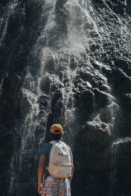 Person by Waterfall on Rocks