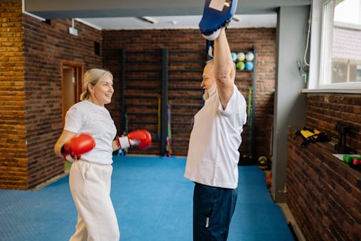 Elderly couple enjoying a fun boxing workout indoors with gloves and mitts.