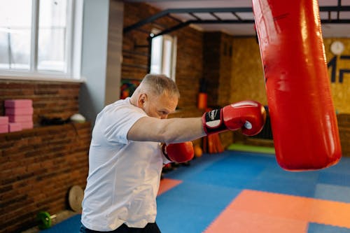 Free A Man in the Gym Doing Punching Bag Routine Stock Photo