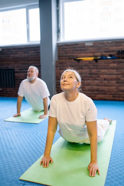 A Woman in the Gym Stretching Her Back While On the Floor