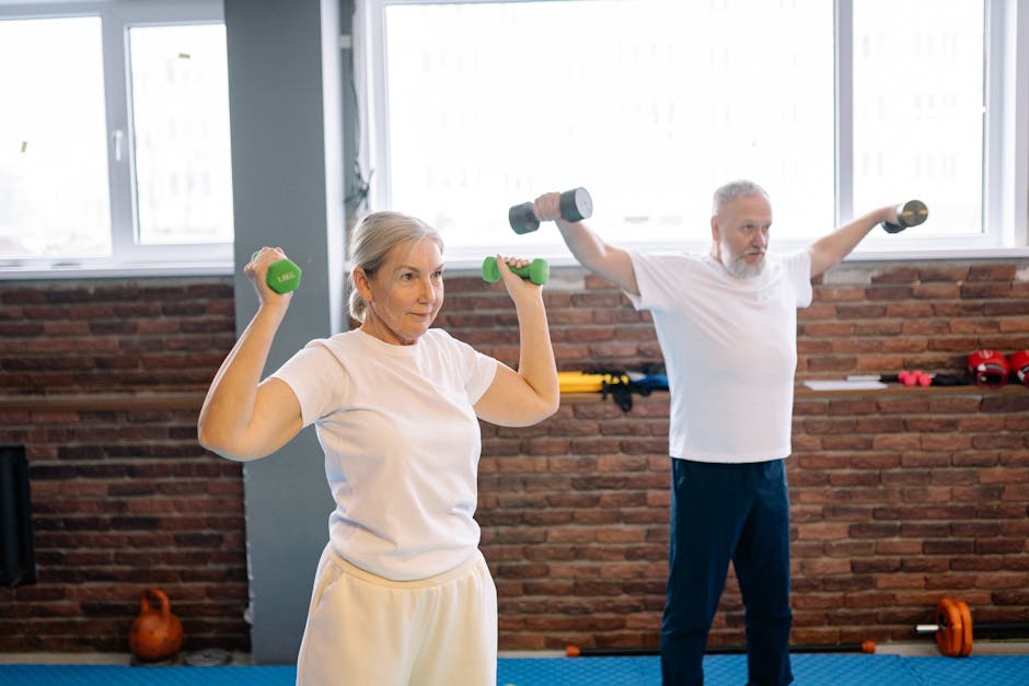 Seniors using light weights in a group setting - fitness classes for over 60s near me Seniors using light weights in a group setting - fitness classes for over 60s near me