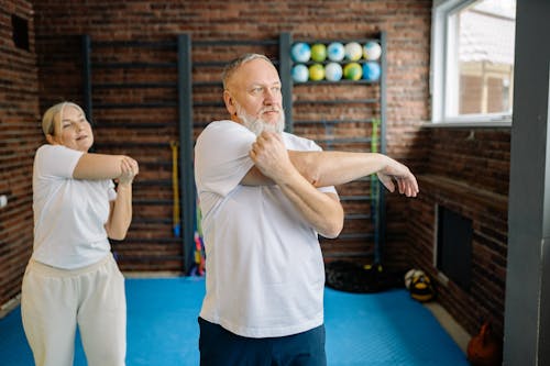 Free An Elderly Couple Doing Arms Stretching Exercise Stock Photo