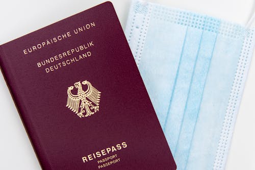 Free A German Passport beside a Surgical Mask Stock Photo