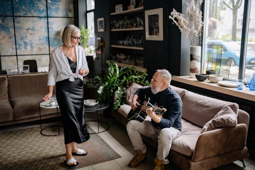 Kostenloses Stock Foto zu akustische gitarre, couch, frau