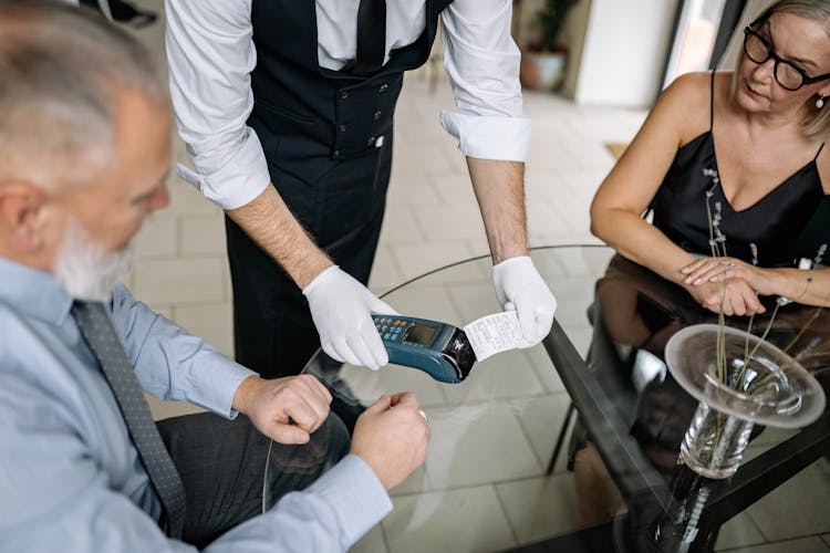 Two People Paying At A Restaurant