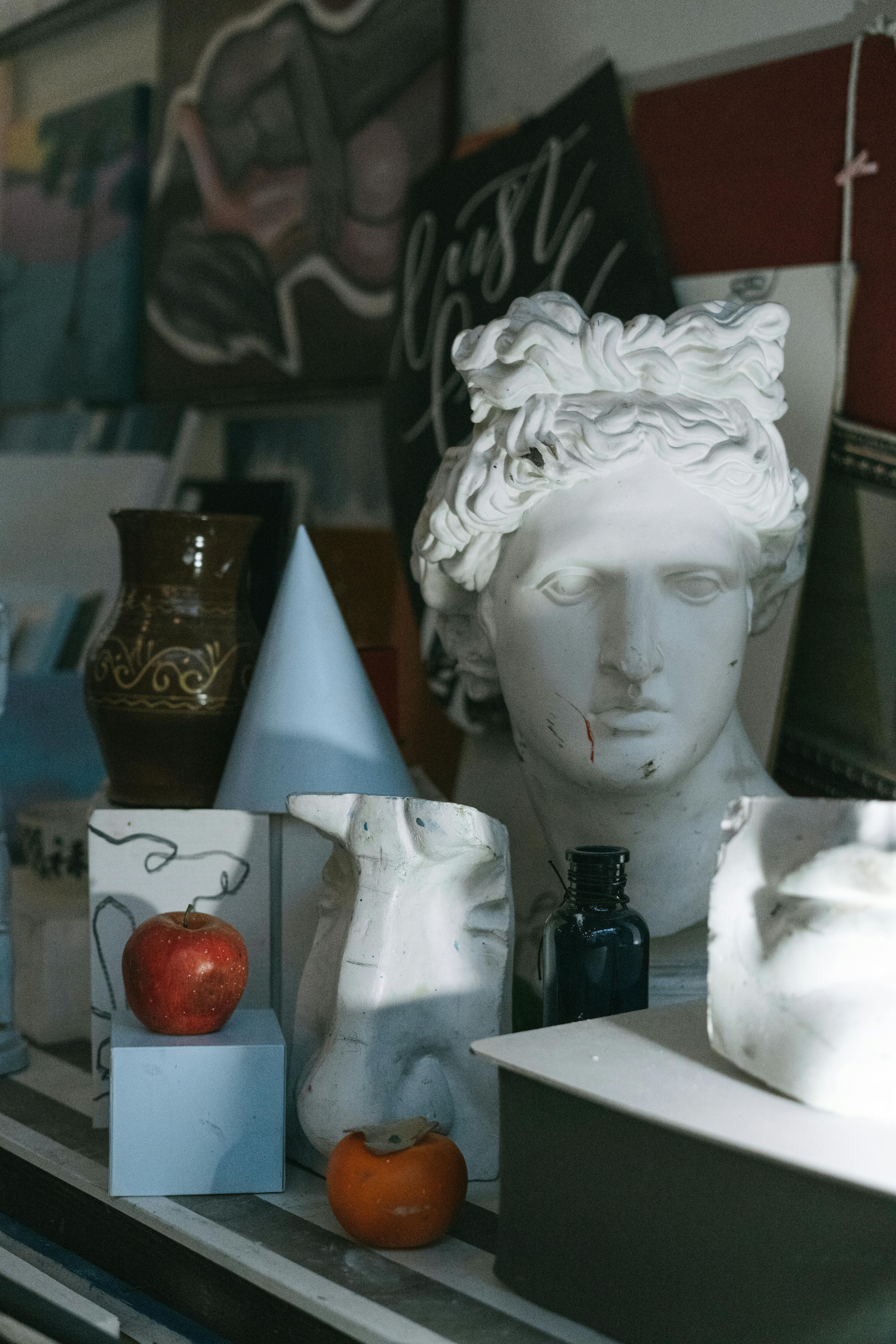 orange fruit beside white ceramic figurine