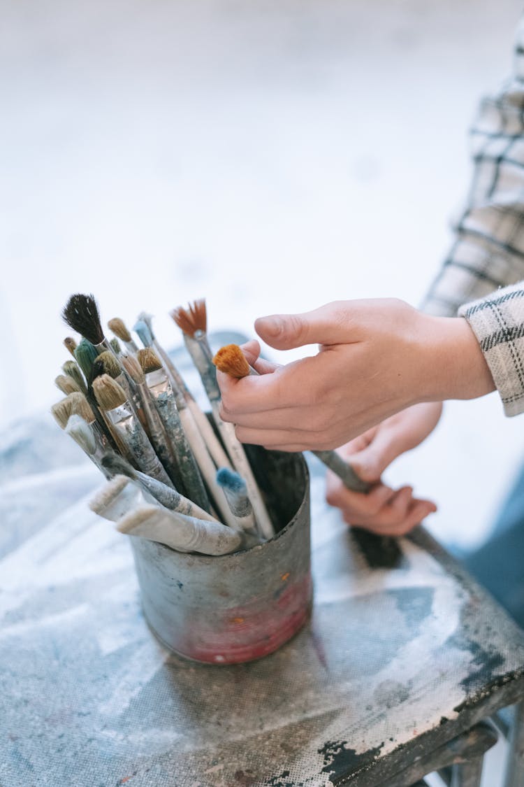 A Hand Getting Paintbrush From The Holder