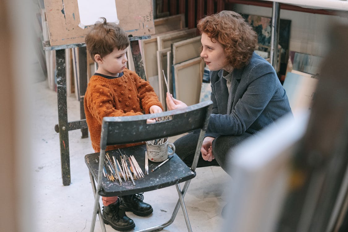 Free A Woman Teaching a Boy About the Art of Painting Stock Photo