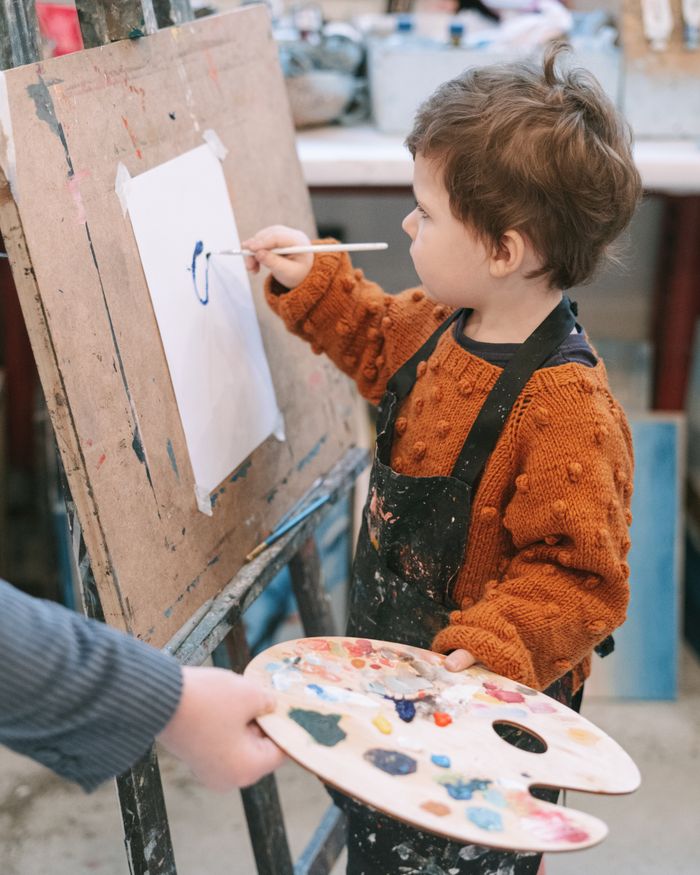 A young child painting at an easel
