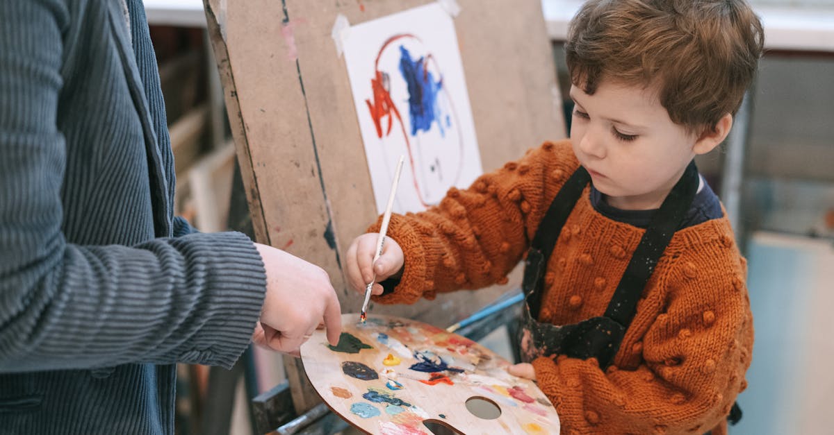 Boy in Orange and Black Zip Up Jacket Holding White and Red Floral Round Plate