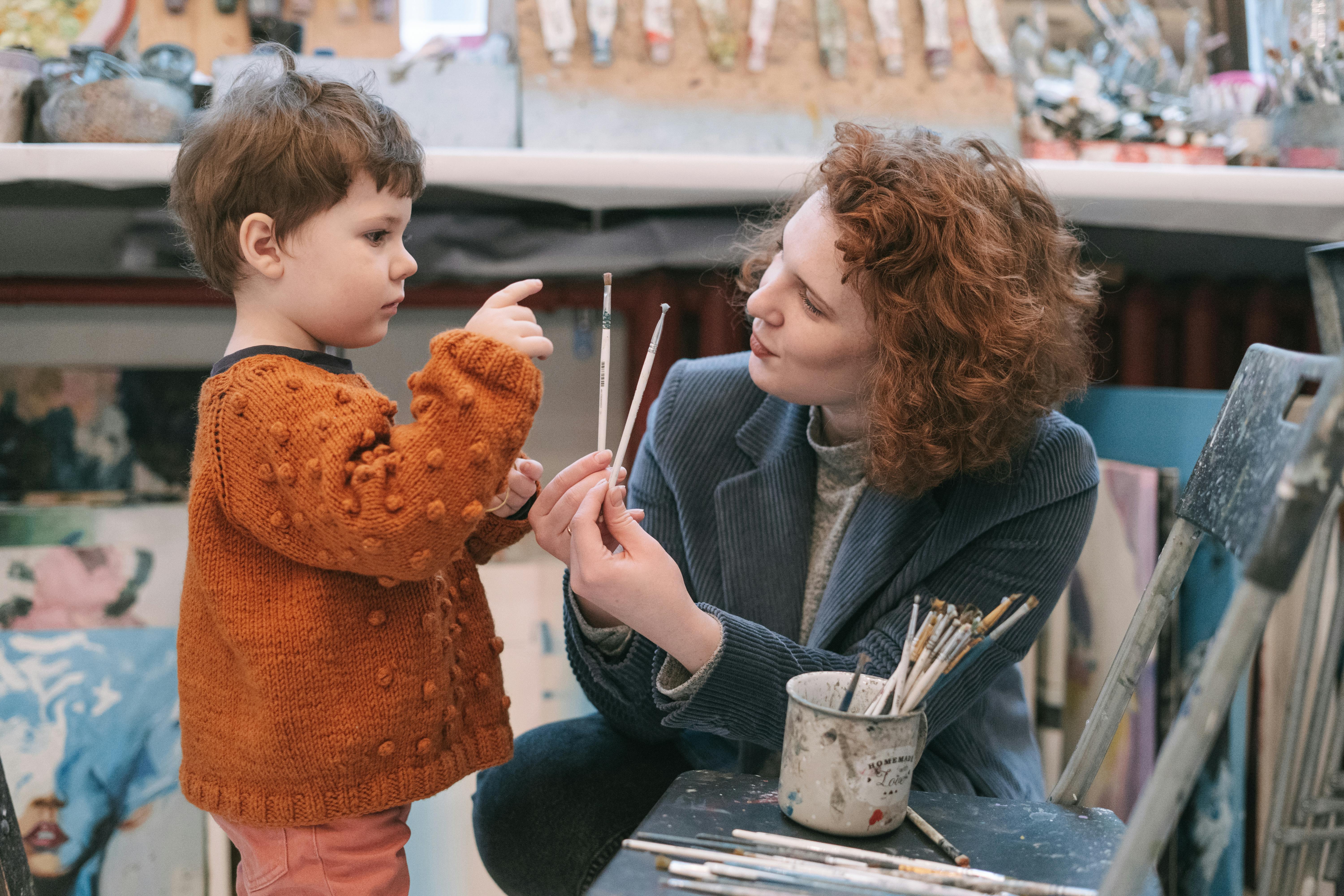 woman in black blazer holding girl in brown sweater