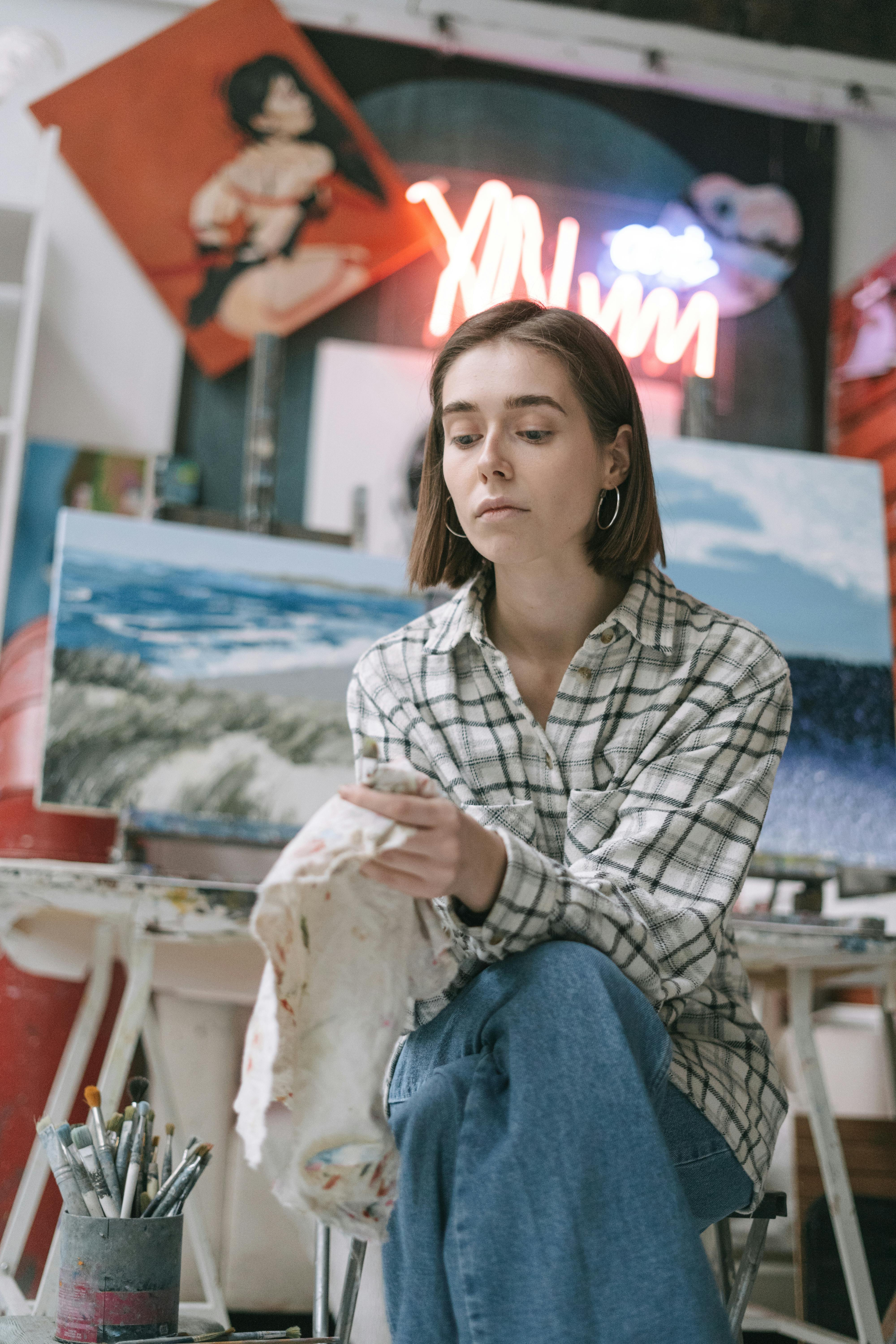 A Woman in White Plaid Long Sleeves Holding White Fabric with Paint Stains