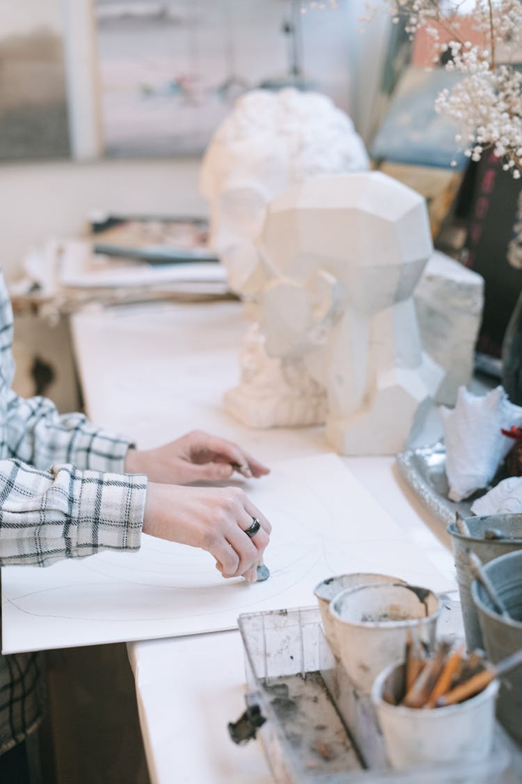 A Person Sketching On The White Board Placed On The Table