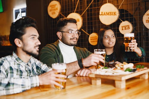 Friends Sitting in Bar Drinking Beer