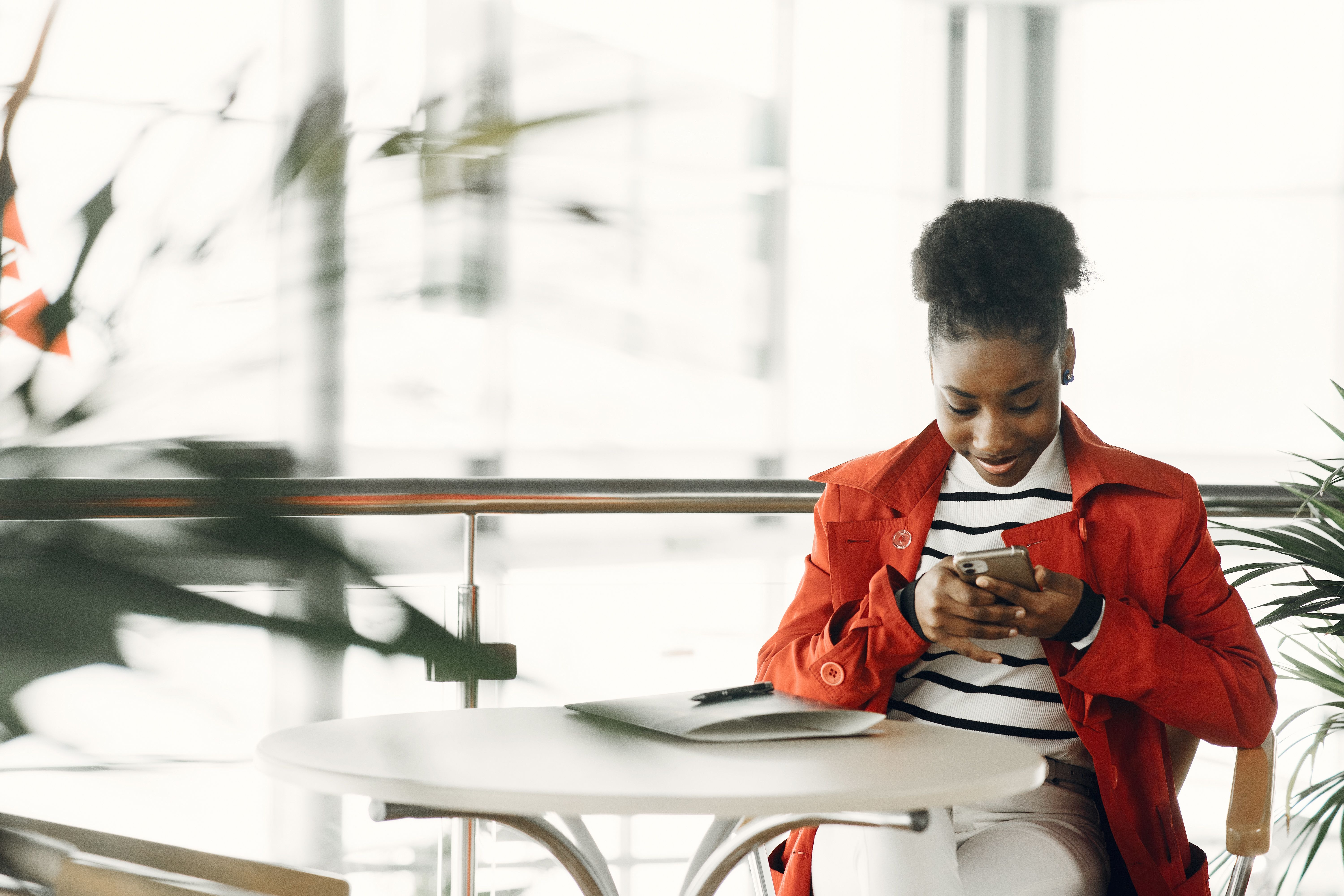 A prospect reading a follow-up email from a coach on their phone at a cafe