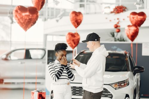 Free A joyful moment as a couple receives car keys in a decorated dealership. Stock Photo