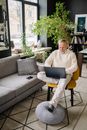 Man Sitting on Chair Using Laptop