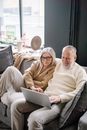 Couple Sitting Together on Couch Using Laptop