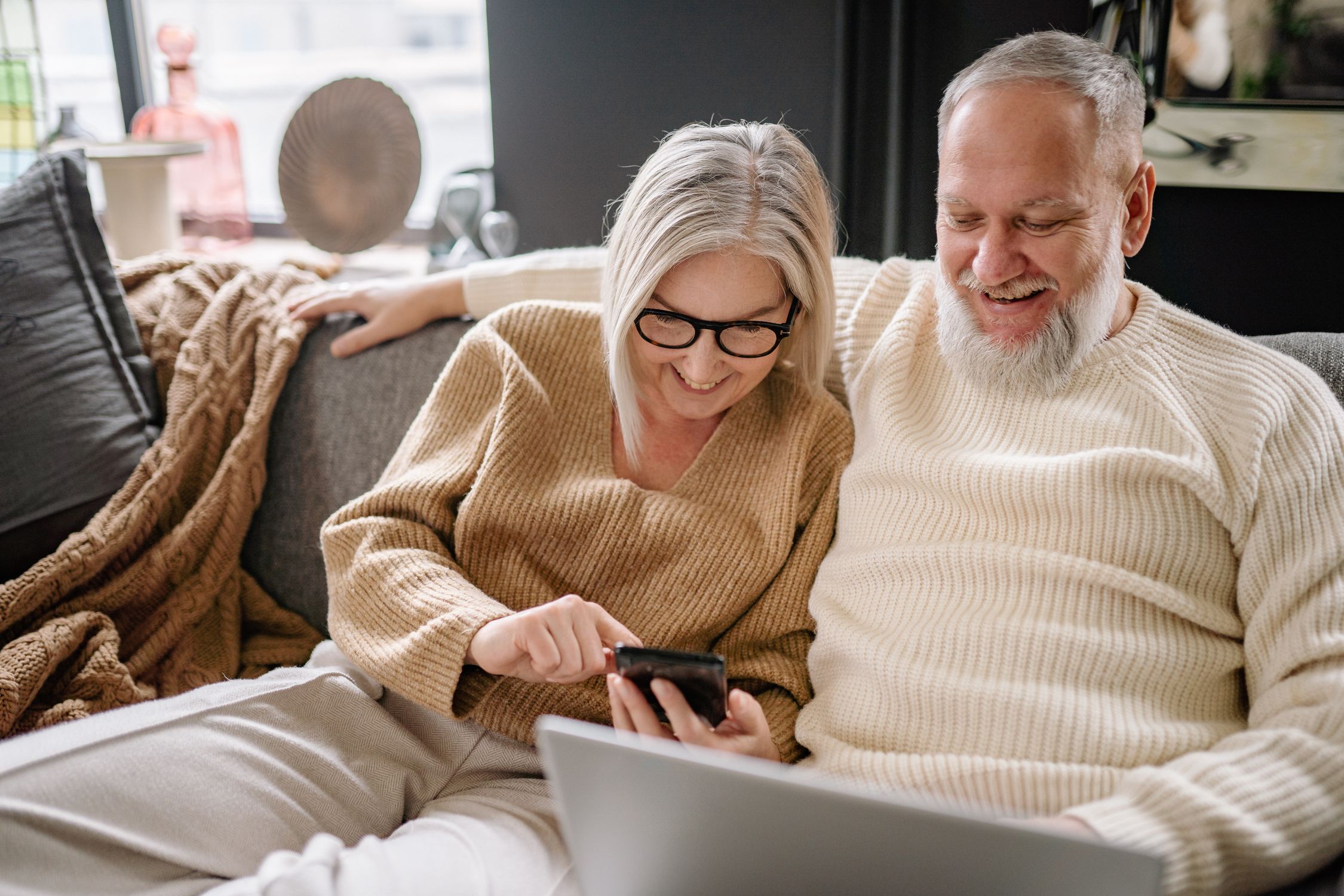 Elderly Couple Sitting on Sofa Using Phone · Free Stock Photo
