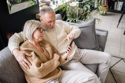 Couple Sharing Earphones while Using Cellphone
