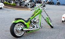 一辆充满活力的定制绿色摩托车，配有镀铬细节，停在户外