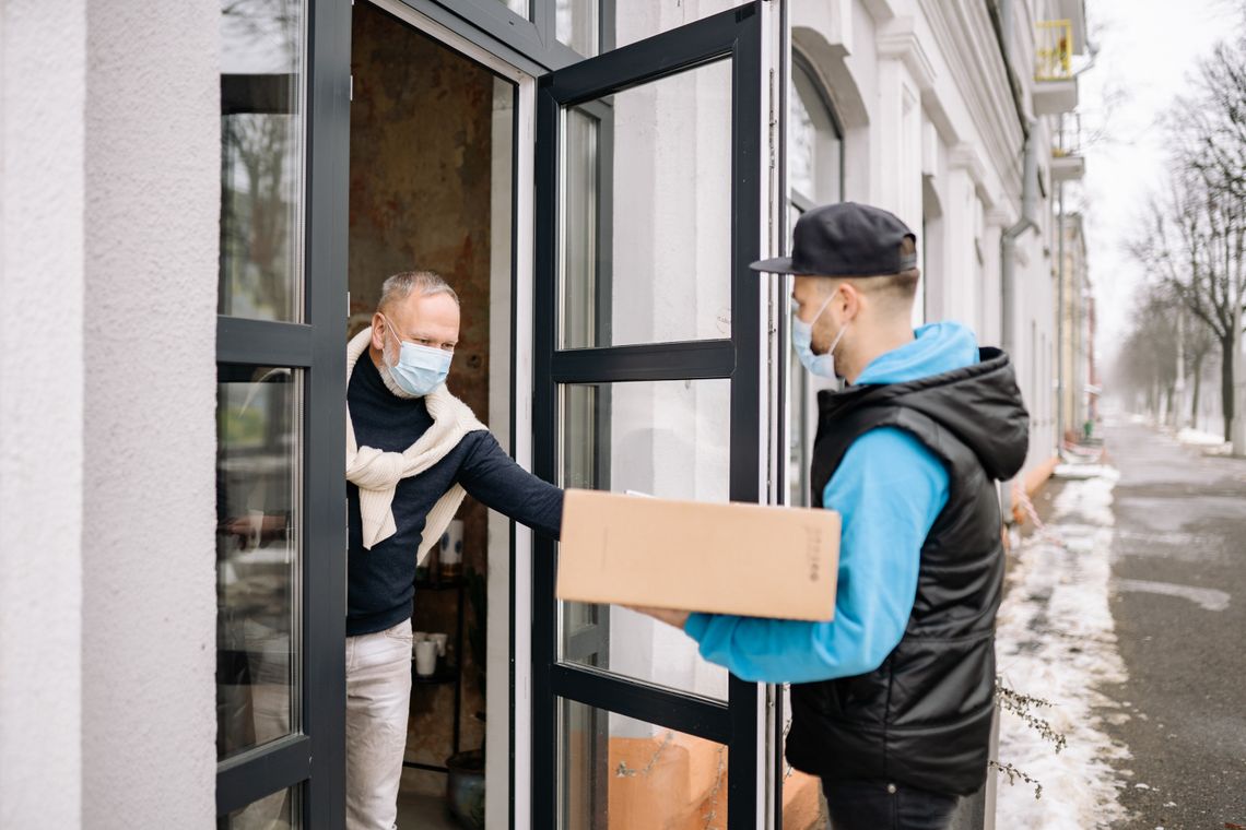 Courier handing a package to a customer at the door