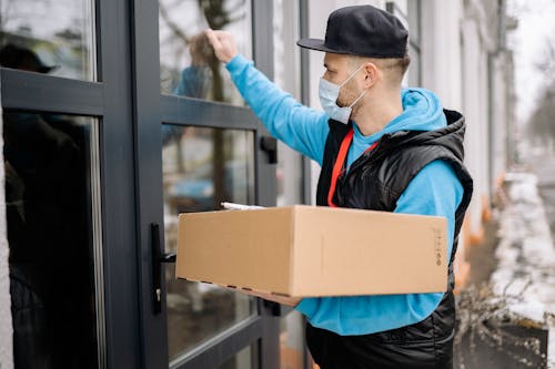 Free Delivery Man Knocking on a Door Stock Photo
