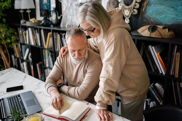 A Couple Reading The Notes On The Planner