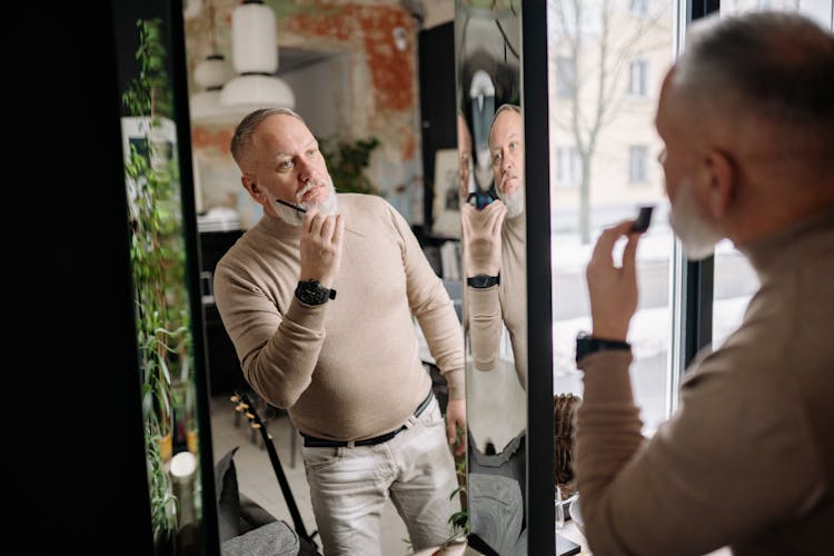 Old Man Looking In Mirror Brushing Beard