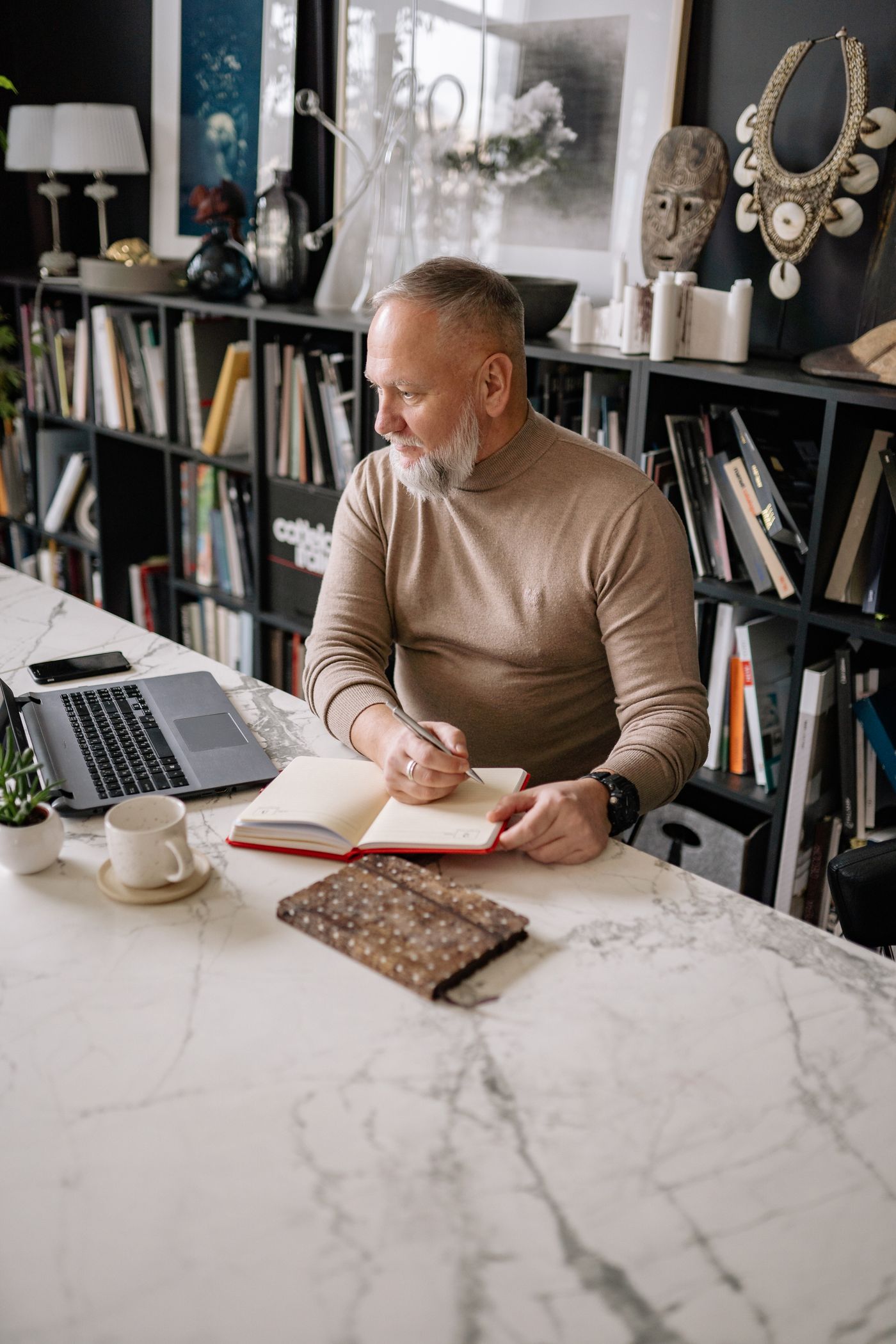 Man writing in a notebook at a desk