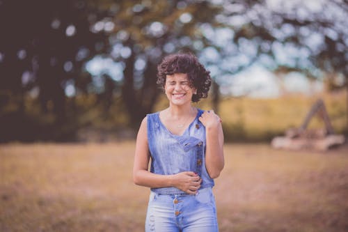 In Afstand Vrouw, Gekleed In Blauwe Ronde Hals Mouwloze Top En Blauwe Denim Bodems