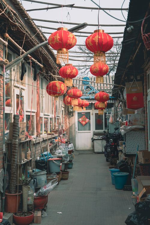 Free A narrow Chinese alley filled with hanging red lanterns and traditional decor, evoking cultural charm. Stock Photo