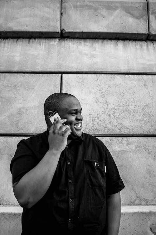 Smiling Man Talking on Cellphone while Looking to His Side