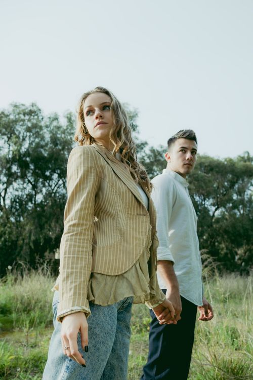 Free A stylish young couple holding hands in a natural outdoor setting. Stock Photo