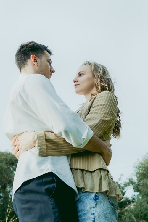 Free A romantic couple embracing outdoors, showcasing intimacy and affection in a serene setting. Stock Photo