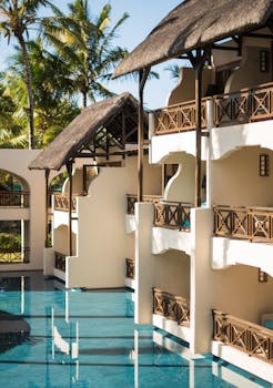 Luxurious tropical resort featuring poolside balconies and palm trees, perfect for a summer getaway.