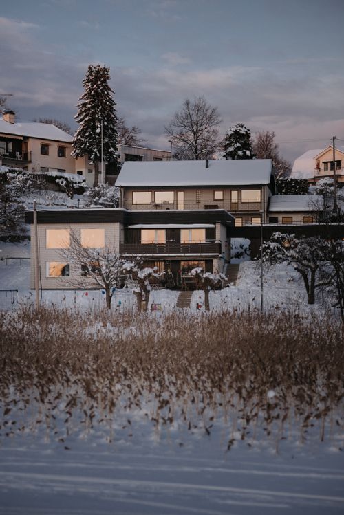 Free Snow-covered houses in Tyresö, Sweden, during winter sunrise. Stock Photo
